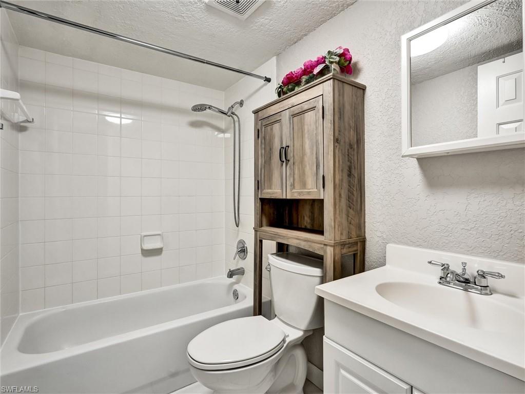 4621 Bayshore Drive, Unit Q1 Naples, FL 34112 - Photo 24 of 25 a bathroom with a sink toilet vanity and shower