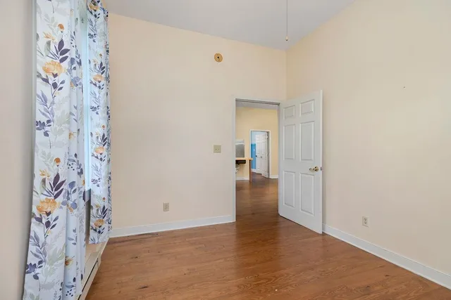 a view of a hallway with wooden floor and furniture