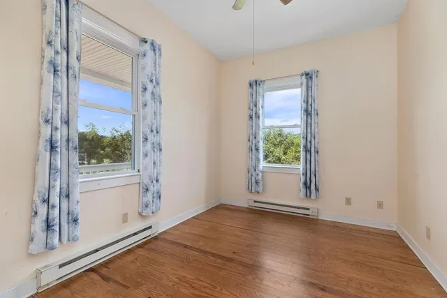 a view of a hallway with wooden floor and windows