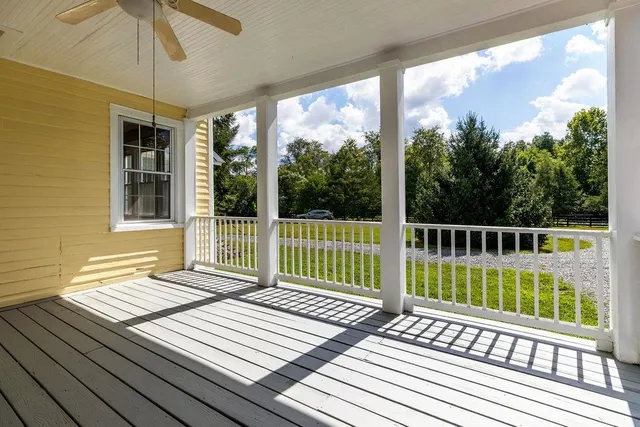 a view of an empty room with wooden floor a fireplace and a window
