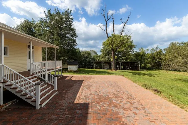 an empty room with wooden floor closet and windows