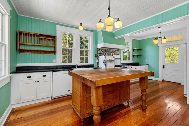 a kitchen with stainless steel appliances granite countertop a stove and a wooden floors
