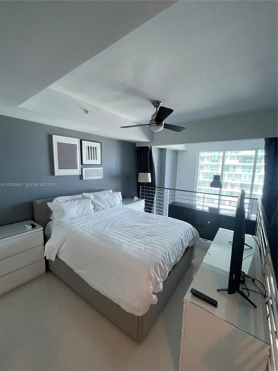60 Southwest 13th Street, Unit 2404 Miami, FL 33130 - Photo 14 of 28 a bedroom with a large bed and a flat tv screen