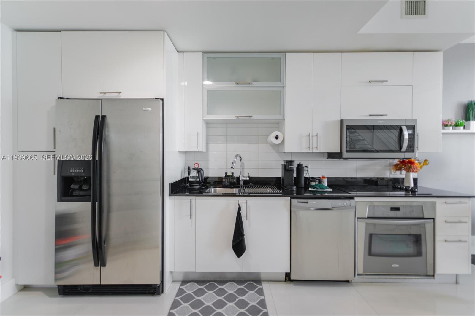 60 Southwest 13th Street, Unit 2404 Miami, FL 33130 - Photo 7 of 28 a kitchen with stainless steel appliances granite countertop a refrigerator and a stove