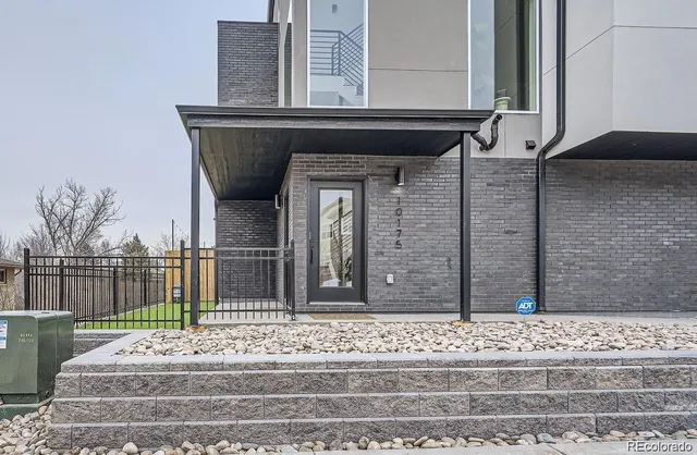 a front view of a house with cars parked