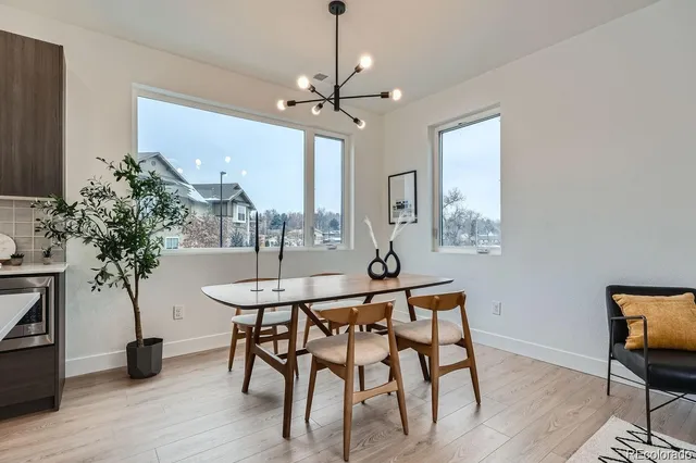 a dining room with furniture a chandelier and wooden floor