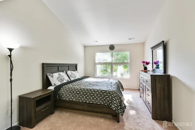 a bedroom with a bed and a dresser next to a window