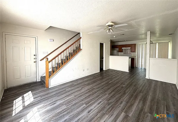 a view of a hallway with wooden floor and staircase