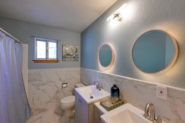 a bathroom with a sink mirror vanity and toilet