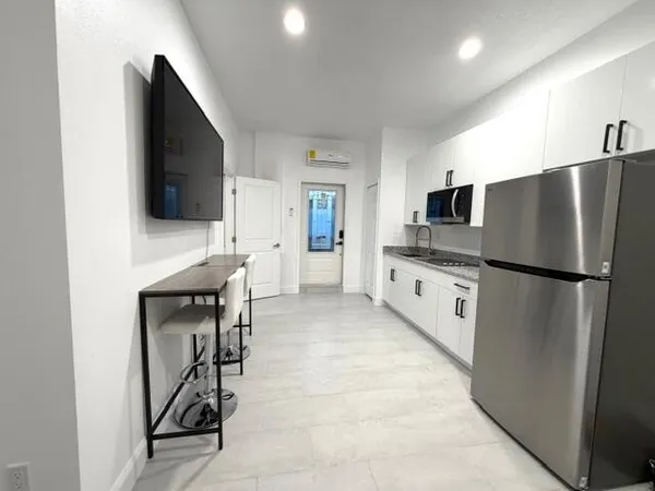 a kitchen with stainless steel appliances a refrigerator and a stove top oven