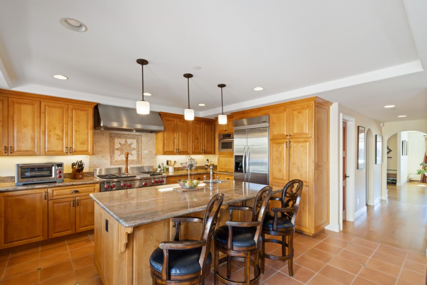 116 Monterey Street Santa Cruz, CA 95060 - Photo 23 of 61 a kitchen with stainless steel appliances kitchen island granite countertop a table chairs and a refrigerator