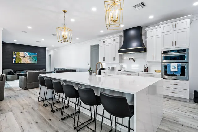 a kitchen with stainless steel appliances a kitchen island hardwood floor sink and stove