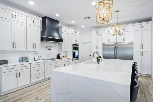 a kitchen with kitchen island white cabinets and refrigerator