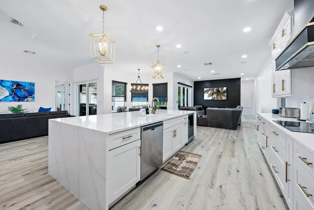 a large kitchen with stainless steel appliances kitchen island granite countertop a lot of cabinets and wooden floor