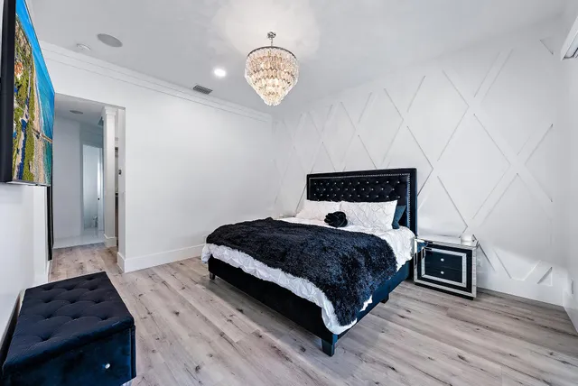 a bedroom with a bed and a chandelier