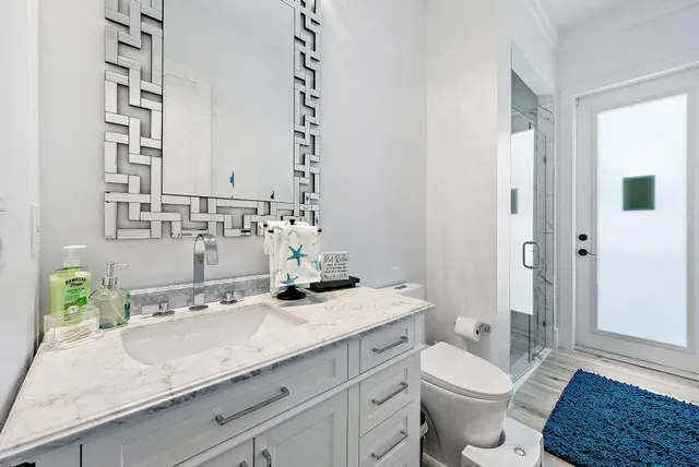 a bathroom with a granite countertop sink mirror vanity and toilet