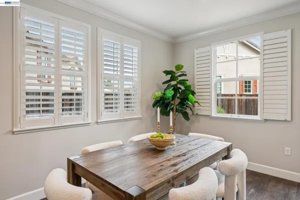 a kitchen with a dining table wooden floor kitchen island stainless steel appliances and living room view