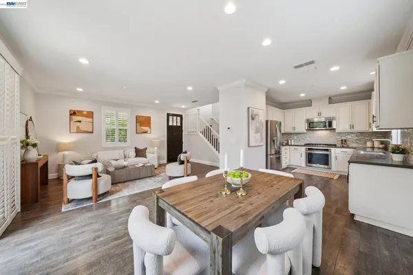 a kitchen with kitchen island granite countertop white cabinets and white appliances