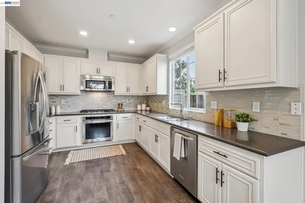 a kitchen with stainless steel appliances granite countertop a stove a refrigerator and a granite counter tops