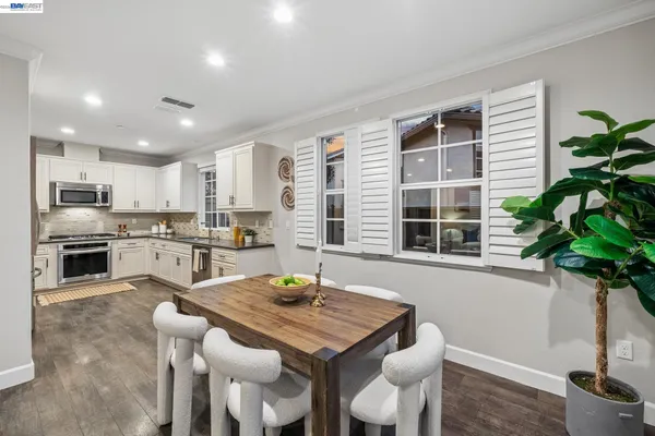 a kitchen with white cabinets and sink