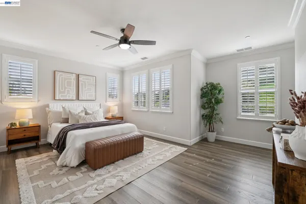 a bedroom with a large bed and a ceiling fan