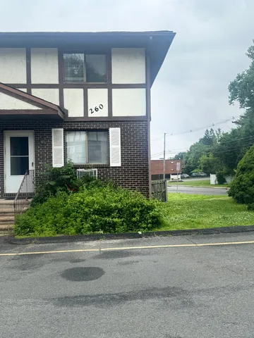 a front view of a house with a yard and potted plants