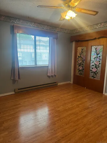 an empty room with wooden floor and windows