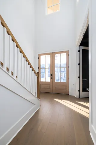 a large kitchen with stainless steel appliances kitchen island granite countertop a large kitchen island a sink dishwasher a refrigerator and white cabinets with wooden floor