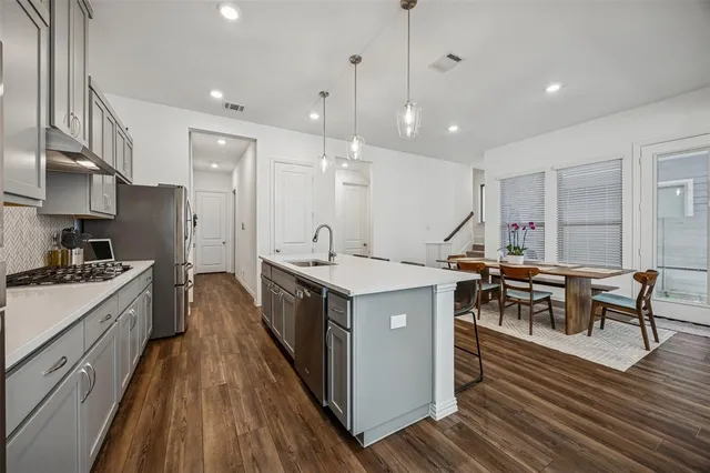 a kitchen with kitchen island a wooden floor and white cabinets