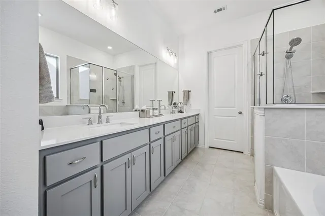 a white bath tub sitting next to a white sink and a mirror
