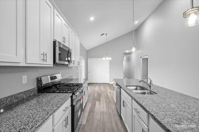 a kitchen with stainless steel appliances granite countertop a sink stove and cabinets