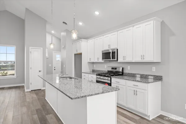 a kitchen with stainless steel appliances granite countertop a sink stove and cabinets