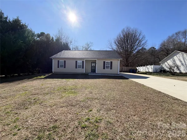 a front view of a house with a yard and trees