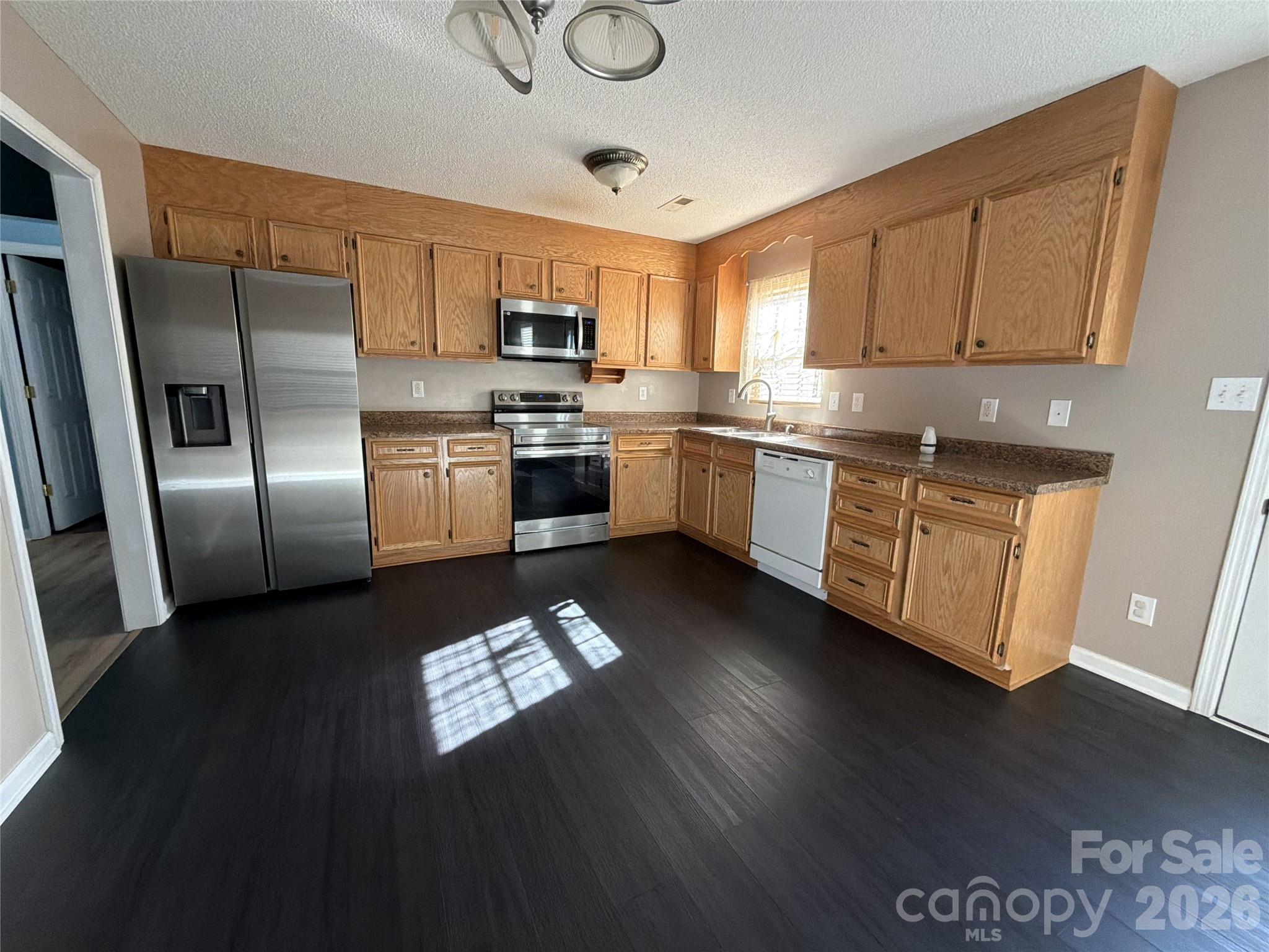 308 Springhill Lane Maiden, NC 28650 - Photo 4 of 21 a kitchen with stainless steel appliances granite countertop a refrigerator a stove top oven a sink and dishwasher