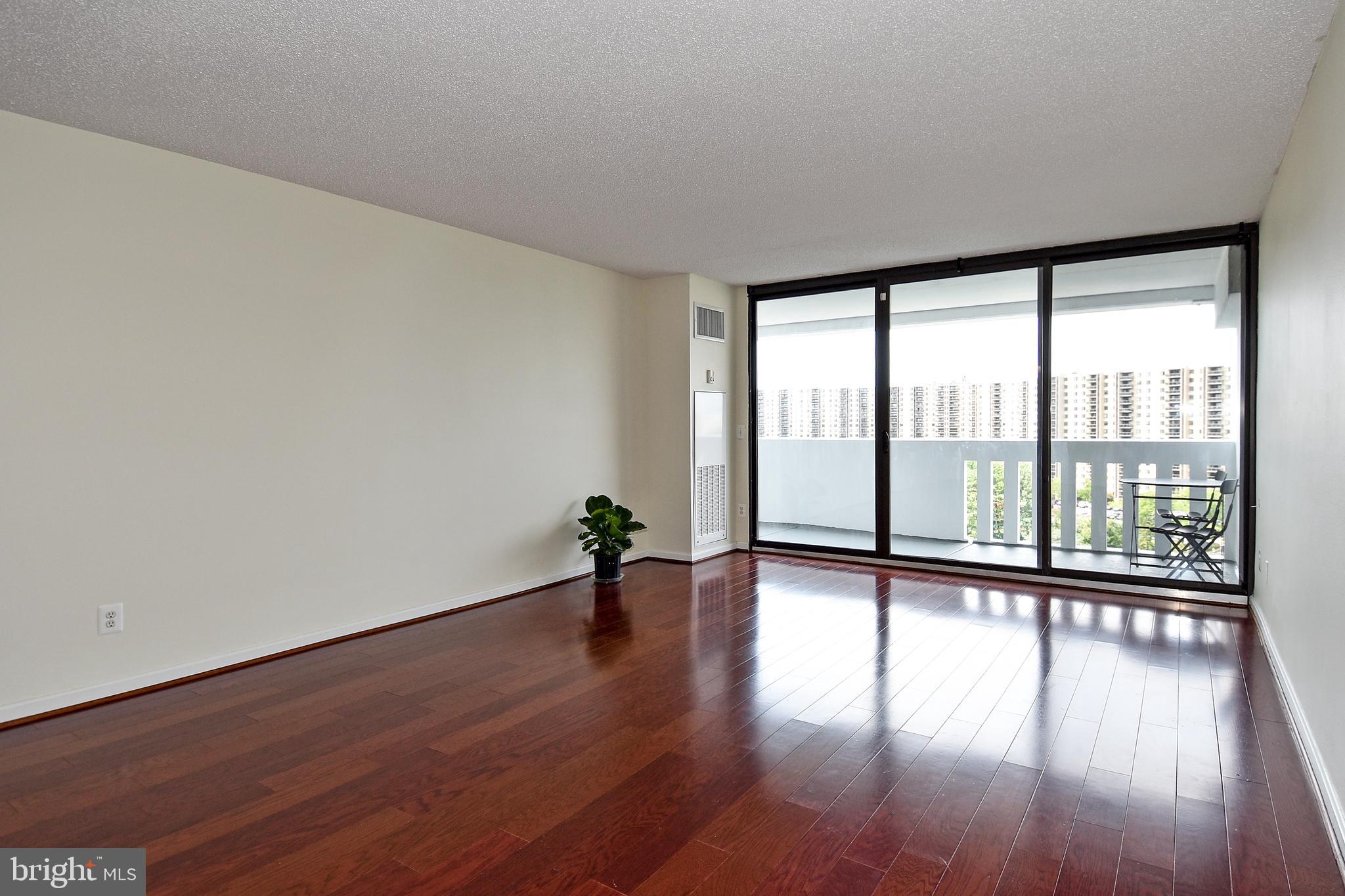 6101 Edsall Road, Unit 1706 Alexandria, VA 22304 - Photo 2 of 40 a view of an empty room with wooden floor and a window