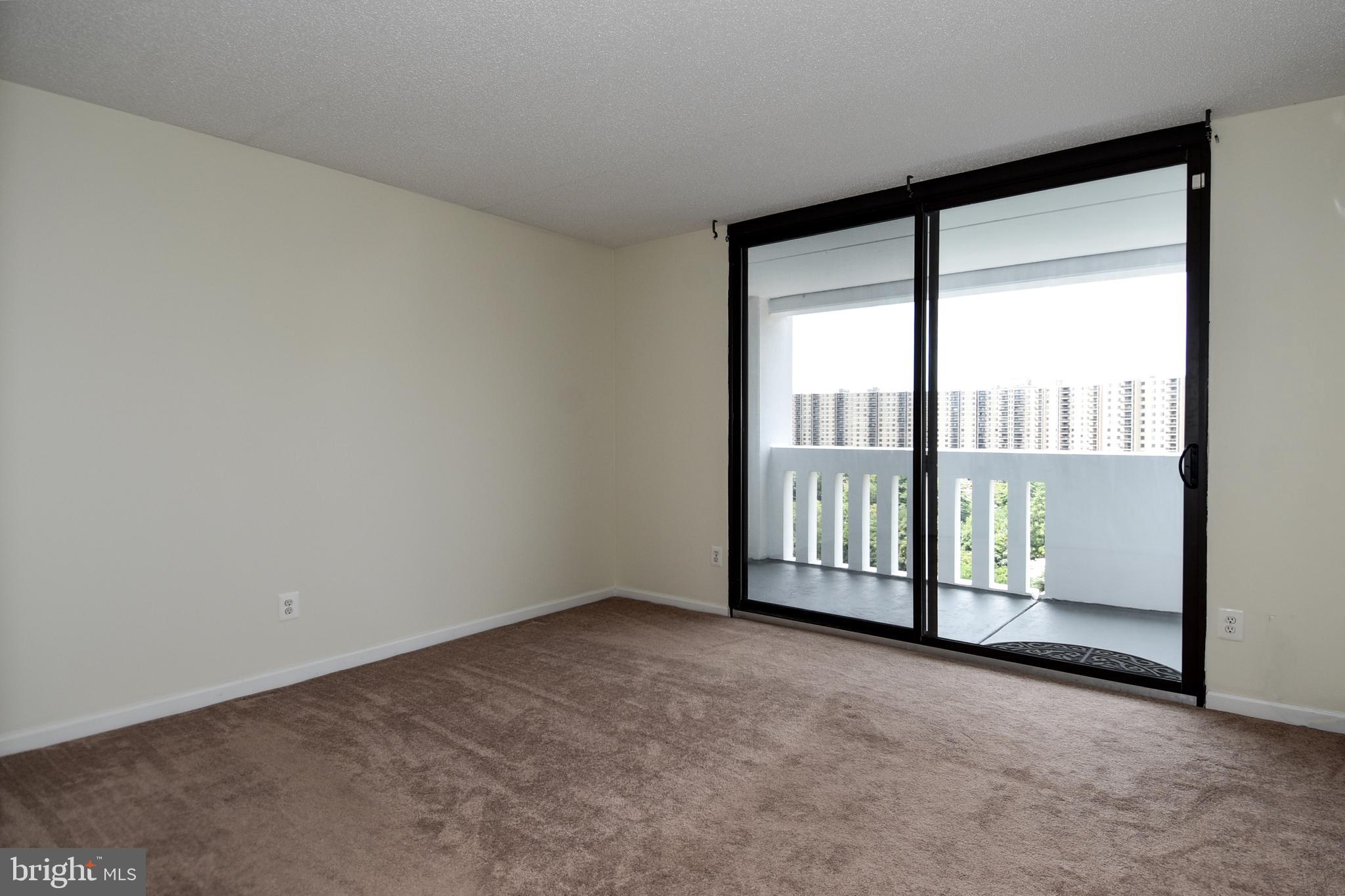 6101 Edsall Road, Unit 1706 Alexandria, VA 22304 - Photo 22 of 40 a view of an empty room with wooden floor and a balcony