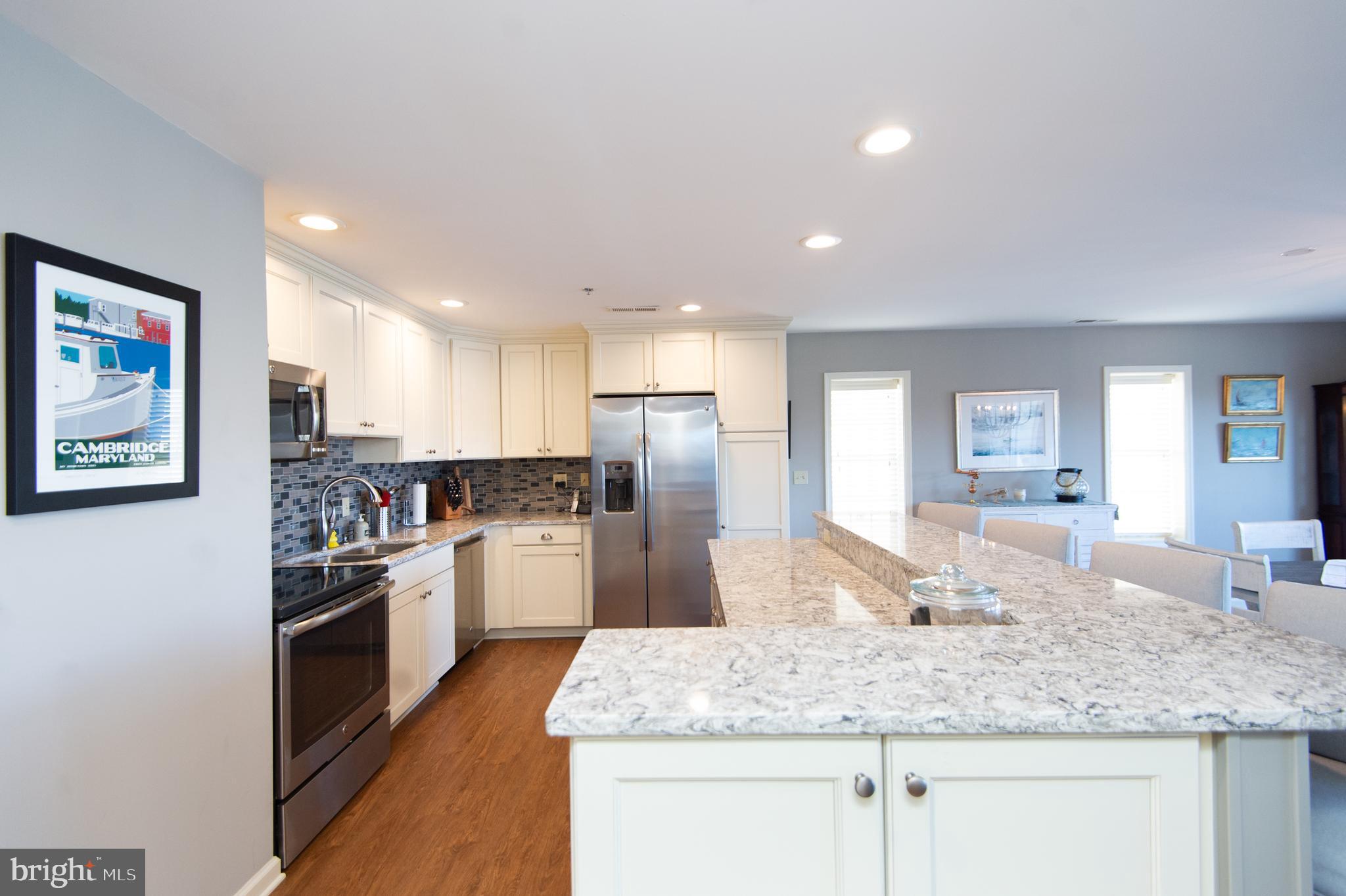 304 Academy Street, Unit 101 Cambridge, MD 21613 - Photo 14 of 56 a kitchen with stainless steel appliances granite countertop a sink refrigerator and cabinets