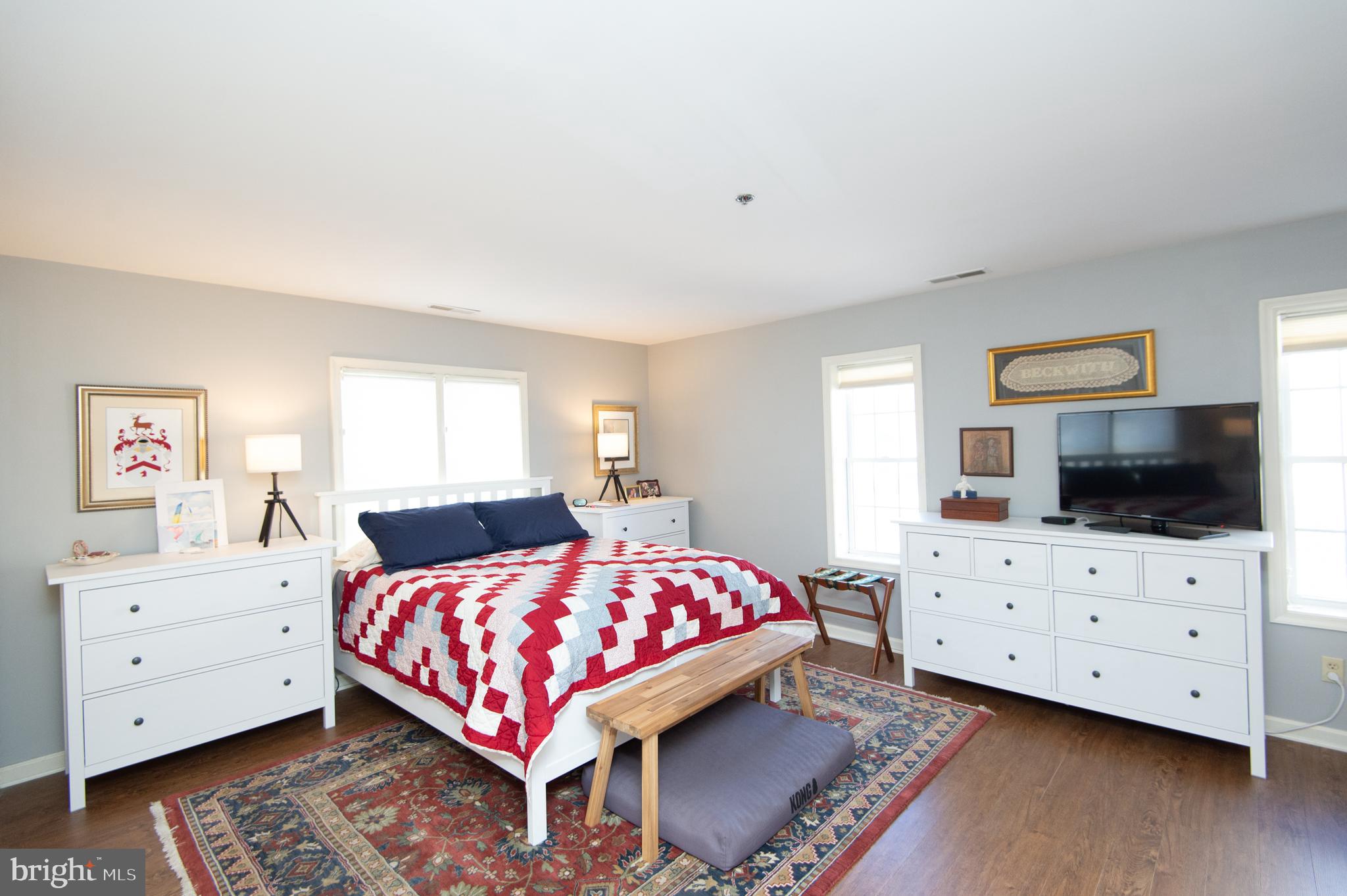 304 Academy Street, Unit 101 Cambridge, MD 21613 - Photo 26 of 56 a bedroom with a bed and flat screen tv