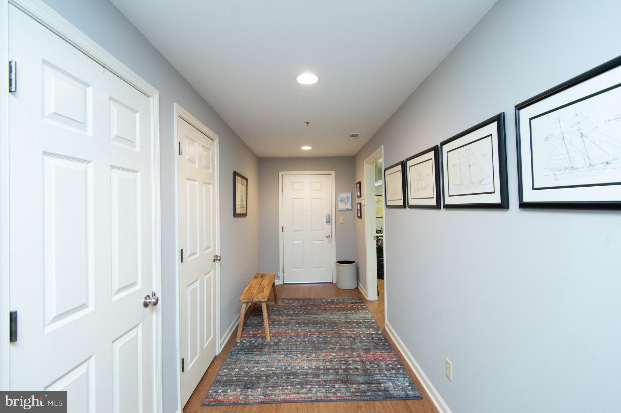304 Academy Street, Unit 101 Cambridge, MD 21613 - Photo 35 of 56 a view of a hallway with wooden floor and white walls