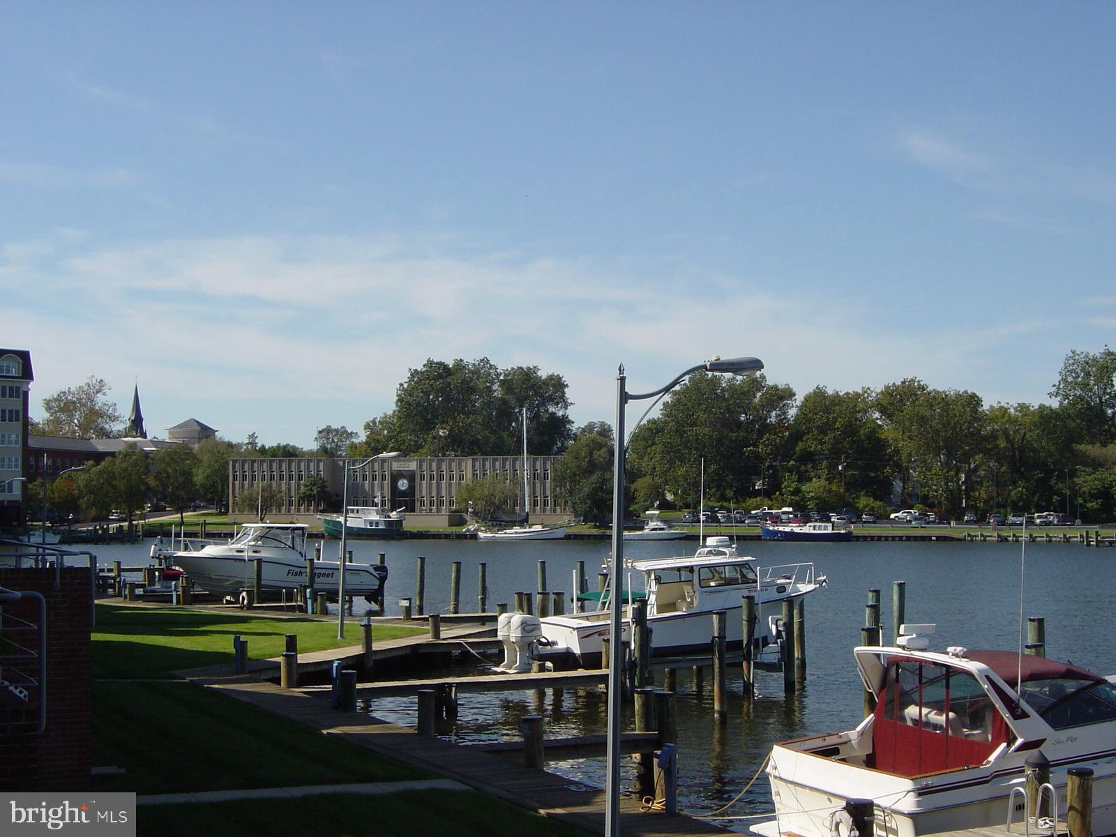 304 Academy Street, Unit 101 Cambridge, MD 21613 - Photo 49 of 56 a view of a lake with a table and chairs