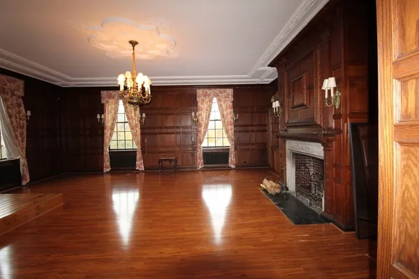 a view of a livingroom with wooden floor fireplace and windows