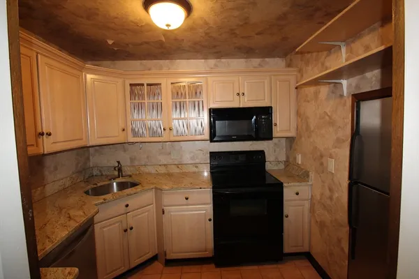 a kitchen with stainless steel appliances granite countertop a refrigerator and a sink
