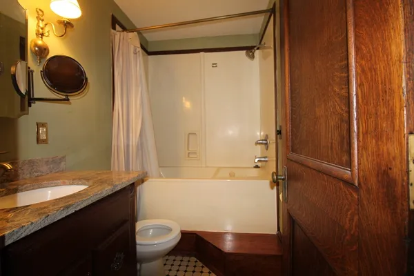 a bathroom with a granite countertop sink toilet and shower