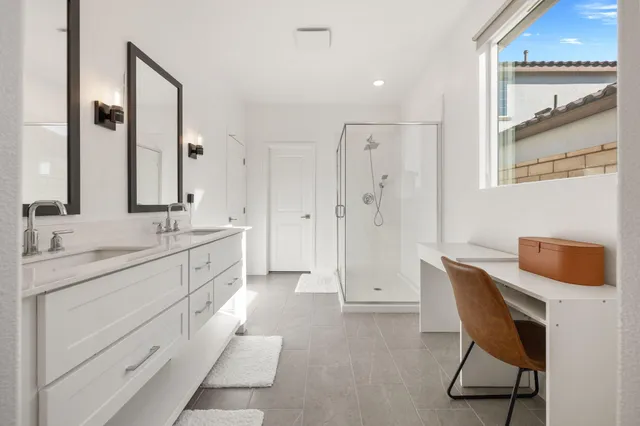 a spacious bathroom with a double vanity sink a mirror and a bathtub
