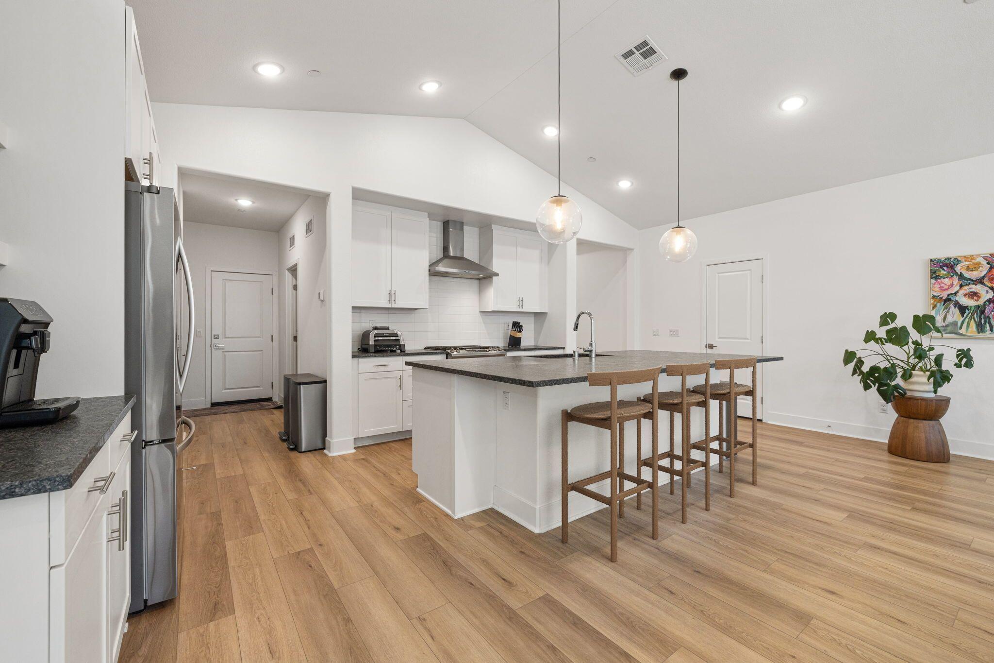 42501 Solicio Way Indio, CA 92203 - Photo 6 of 34 a kitchen with kitchen island stainless steel appliances a dining table chairs sink and stove