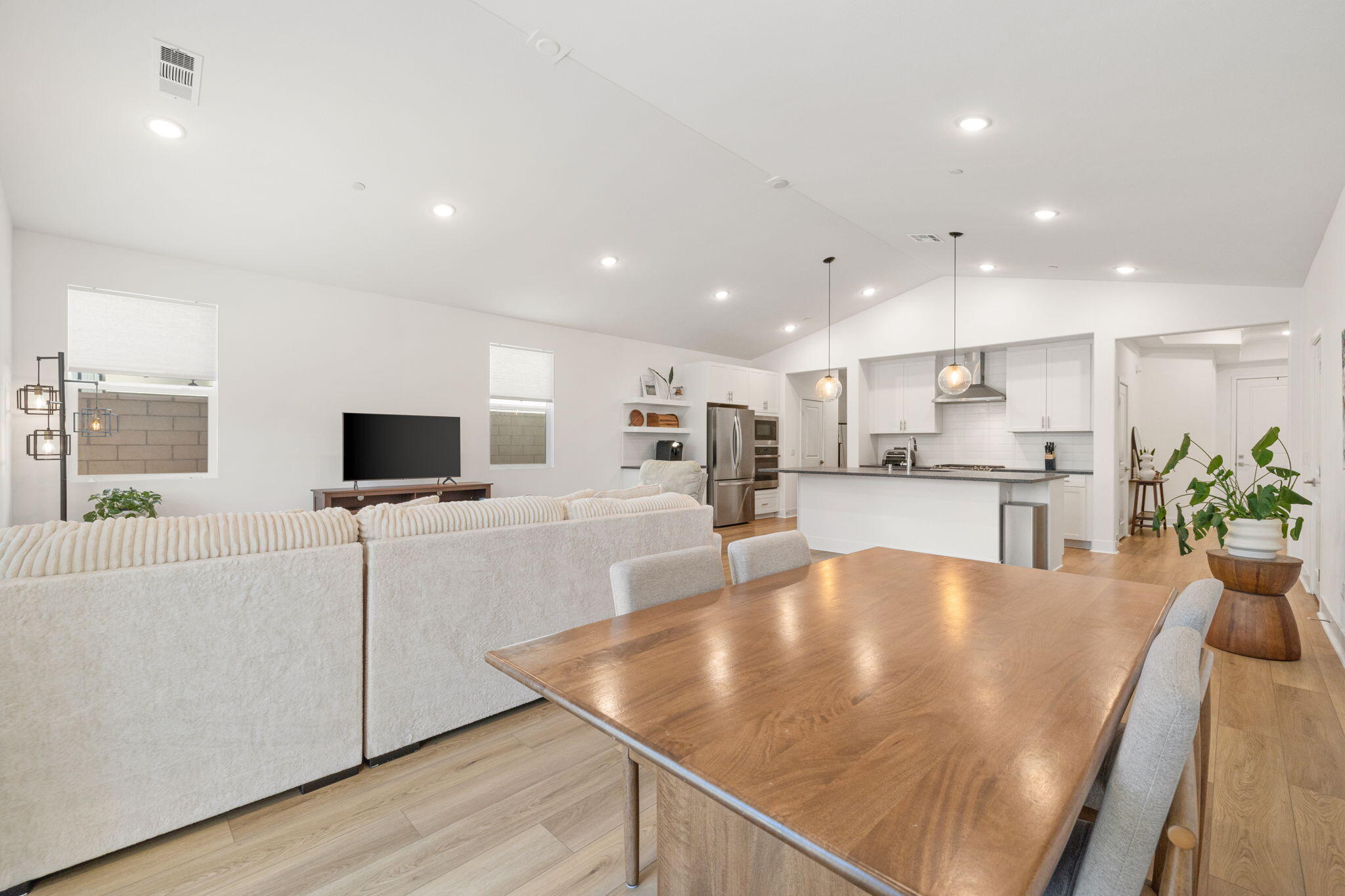 42501 Solicio Way Indio, CA 92203 - Photo 10 of 34 a kitchen with stainless steel appliances granite countertop a sink a stove a microwave a refrigerator a microwave oven and a dining table with wooden floor