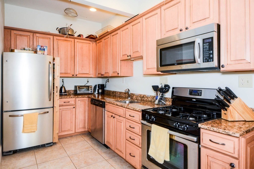 137 Paul Gore Street, Unit 2 Boston, MA 02130 - Photo 1 of 11 a kitchen with stainless steel appliances granite countertop a stove a refrigerator and a microwave