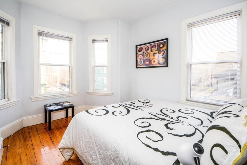 137 Paul Gore Street, Unit 2 Boston, MA 02130 - Photo 6 of 11 a bedroom with a bed and a table in it with window
