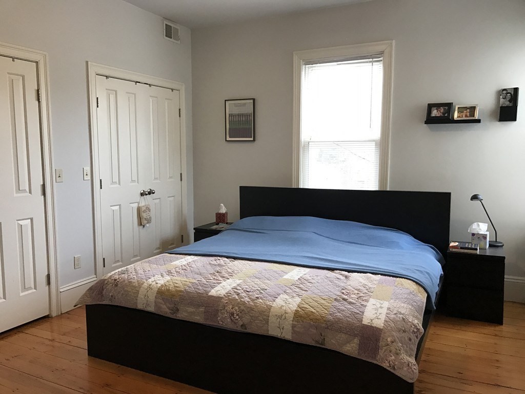 137 Paul Gore Street, Unit 2 Boston, MA 02130 - Photo 10 of 11 a bedroom with a bed and wooden floor