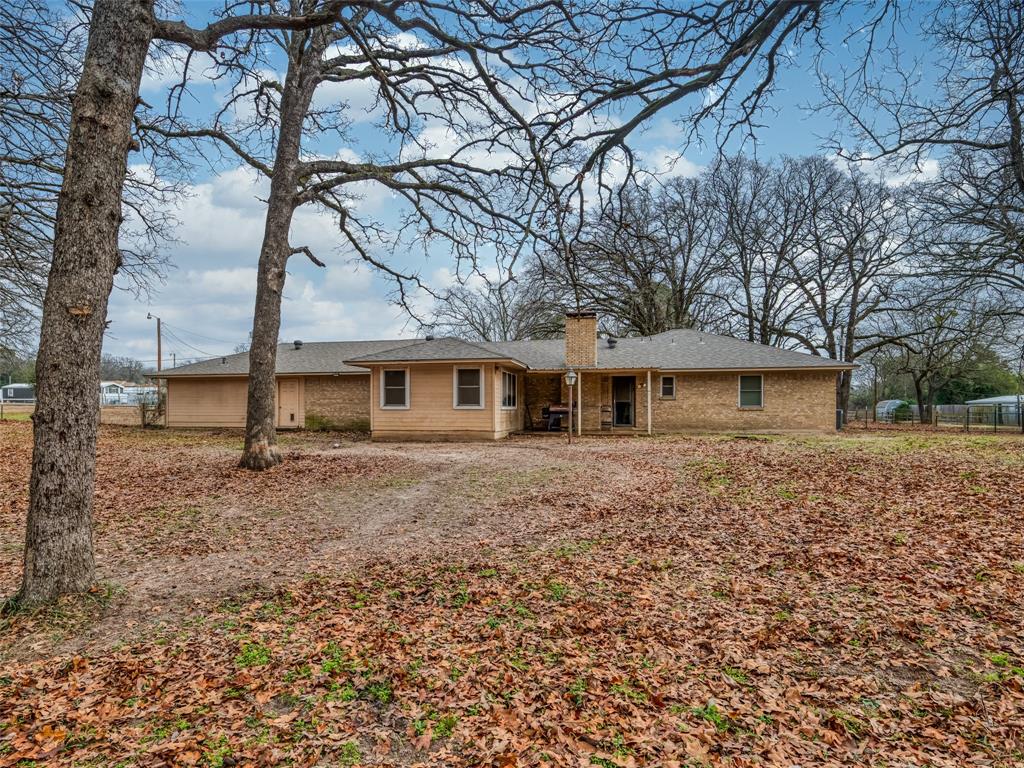 9663 Matise Street Tyler, TX 75706 - Photo 2 of 15 a view of a yard in front of a house with large trees